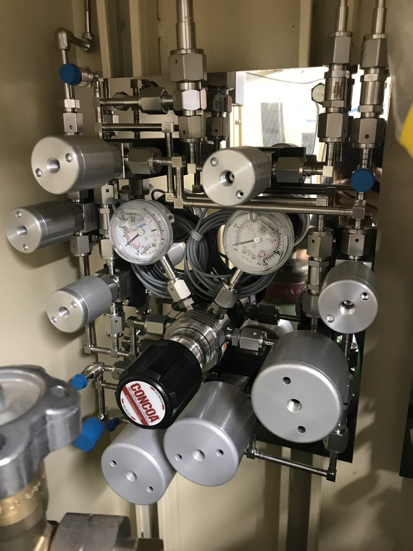 Custom-built gas panel with regulators, pneumatic valves, check valves and a venturi, welded together as one assembly on a compact mounting plate
