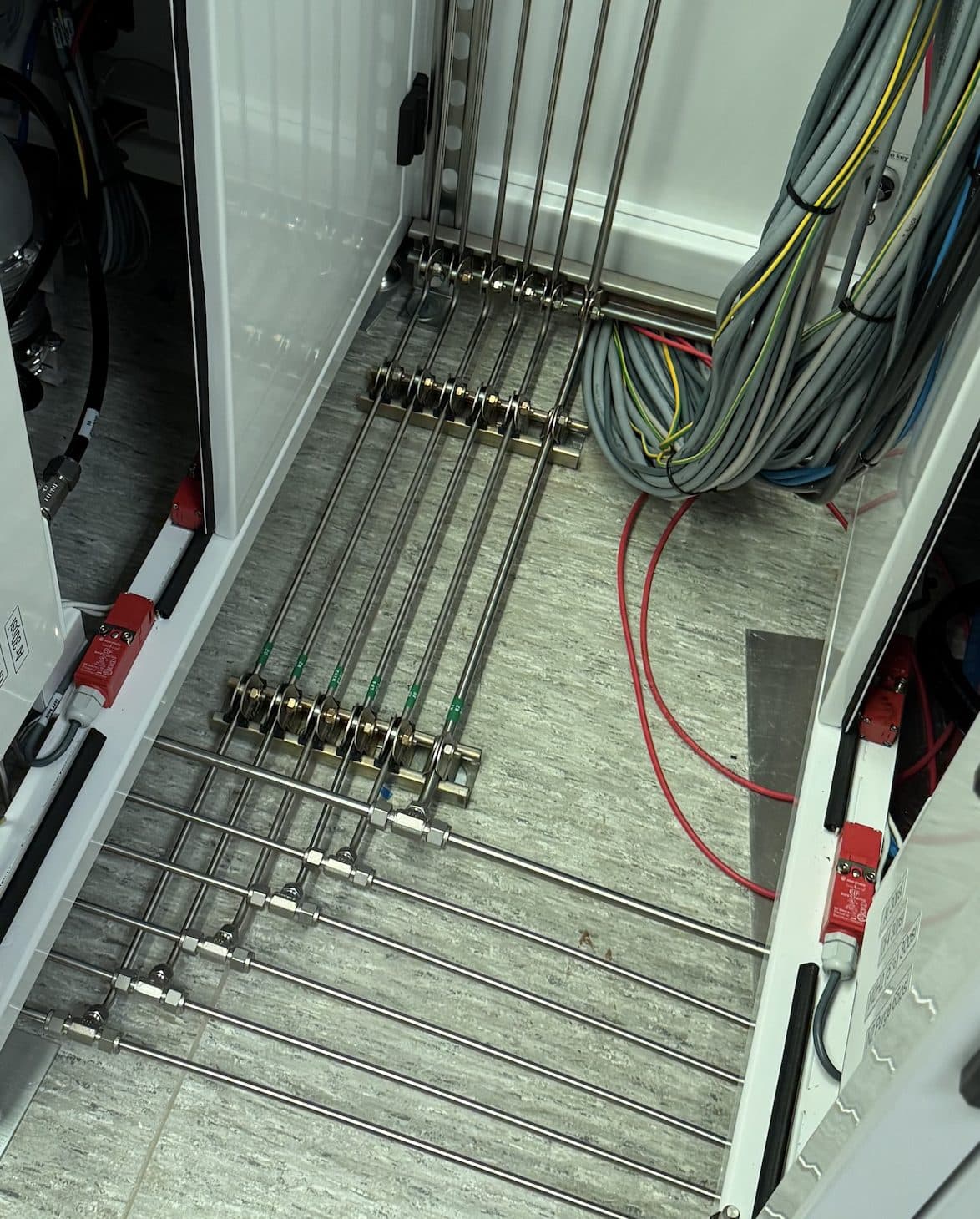 Parallel runs of orbital-welded stainless steel tubing, evenly spaced and clamped on consistent centres